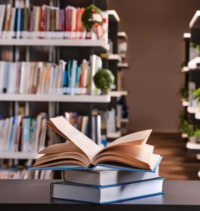 Open books behind glasses and cup of coffee