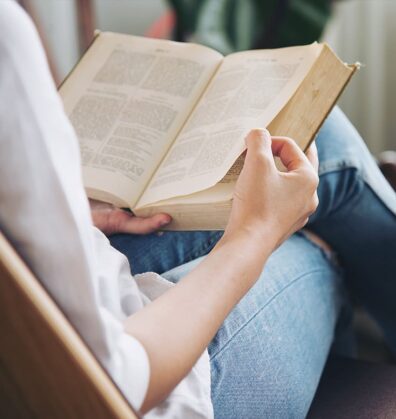 Open books behind glasses and cup of coffee