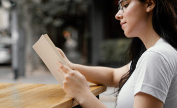 Girl is wearing glasses reading the book